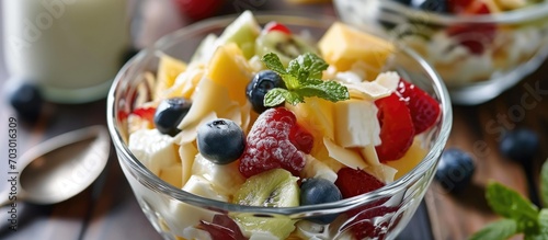 Blurred fruit salad with cheese and milk on top.