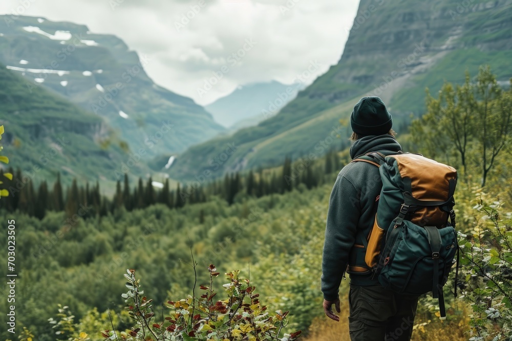 Male model enjoying a solo backpacking trip in a mountainous landscape