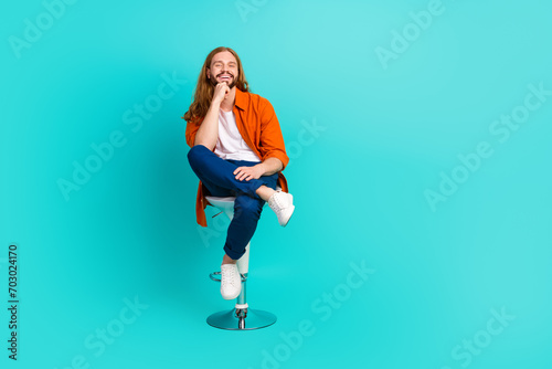 Fototapeta Naklejka Na Ścianę i Meble -  Full size photo of positive guy with long hairdo sit on stool in barbershop get new haircut isolated on turquoise color background
