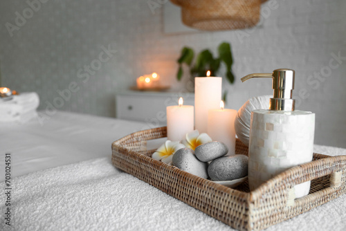 Spa composition with burning candles on couch in salon  closeup