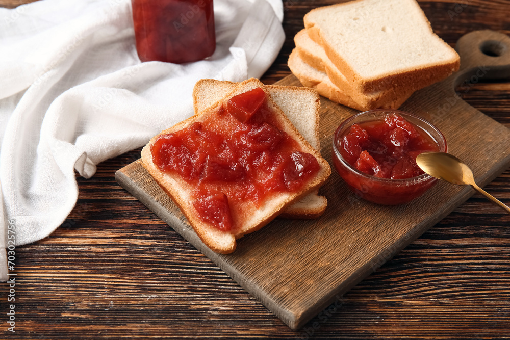 Board with delicious quince jam toasts on wooden background, closeup Board with delicious quince jam toasts on wooden background, closeup