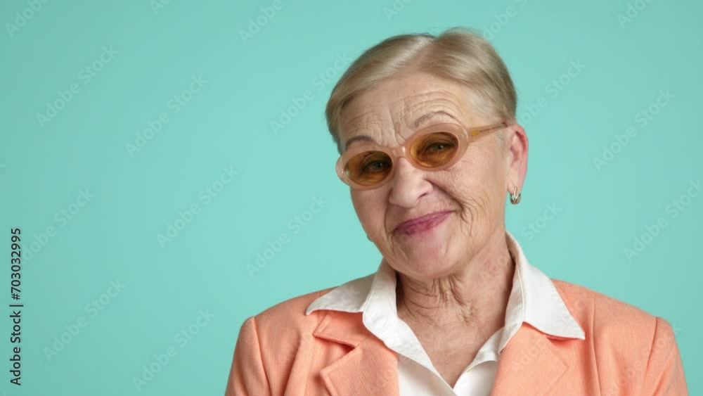Nice senior woman with short blonde hair, deep wrinkles, light make up smiling, flirting, biting lower lip, touching chin seductively on green background. High quality 4k footage Nice senior woman with short blonde hair, deep wrinkles, light make up smiling, flirting, biting lower lip, touching chin seductively on green background. High quality 4k footage
