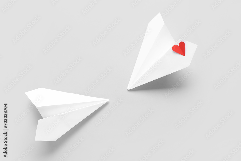 Paper planes and red heart on grey background. Valentine's Day celebration Paper planes and red heart on grey background. Valentine's Day celebration
