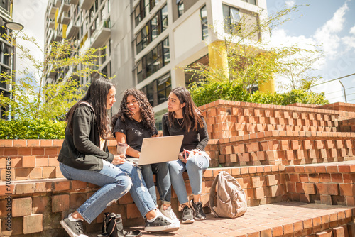 Friends enjoy the good weather in the rest area of their school.