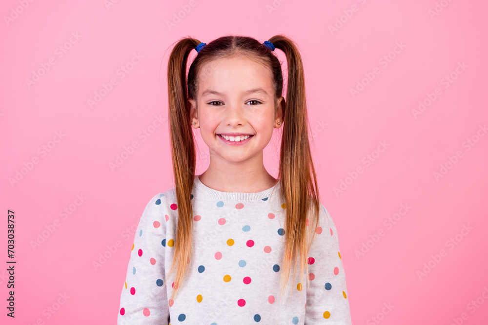 Photo of good mood nice adorable small girl with tails hairstyle wear stylish dotted sweatshirt smiling isolated on pink color background Photo of good mood nice adorable small girl with tails hairstyle wear stylish dotted sweatshirt smiling isolated on pink color background
