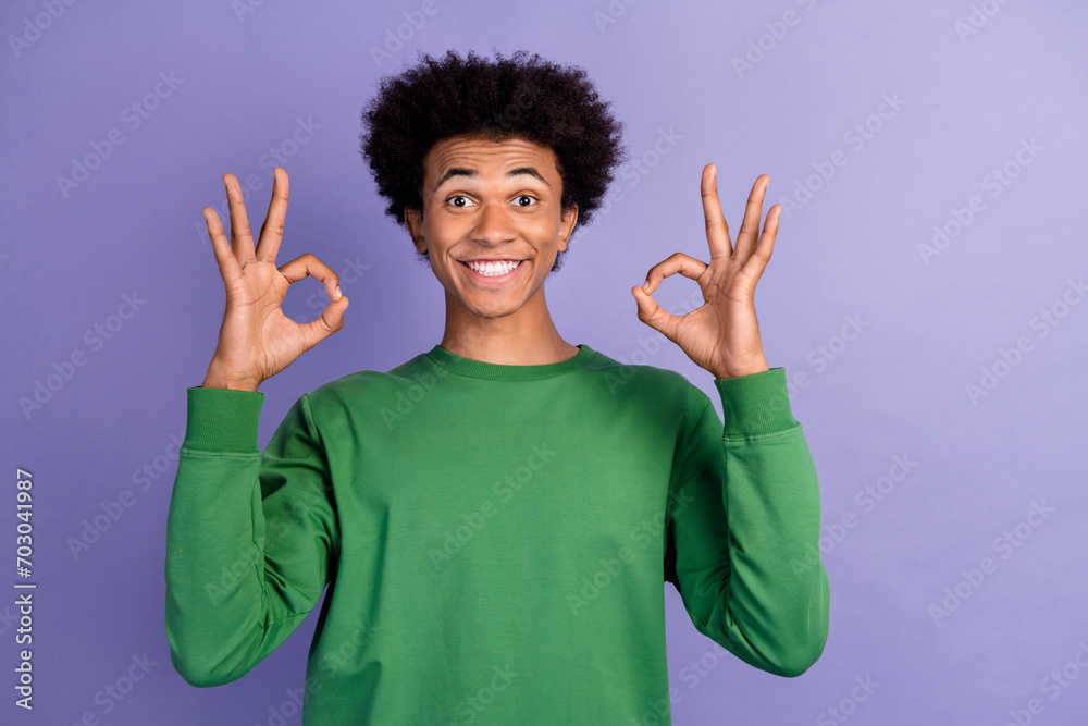 Photo of charming attractive man dressed green sweater showing two okey signs isolated violet color background Photo of charming attractive man dressed green sweater showing two okey signs isolated violet color background