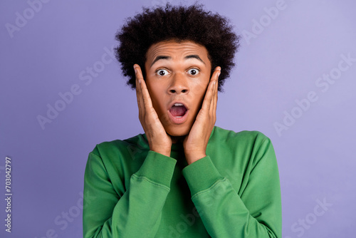 Photo of funky shocked man dressed green sweater open mouth arms cheeks isolated violet color background