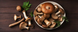 Forest mushrooms in a rustic bowl with herbs on wooden table, top view