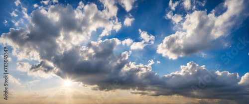 Blue sky and clouds background with sun reflection and sunbeams