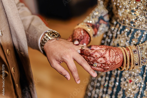 Indian couple's exchanging wedding rings hands close up