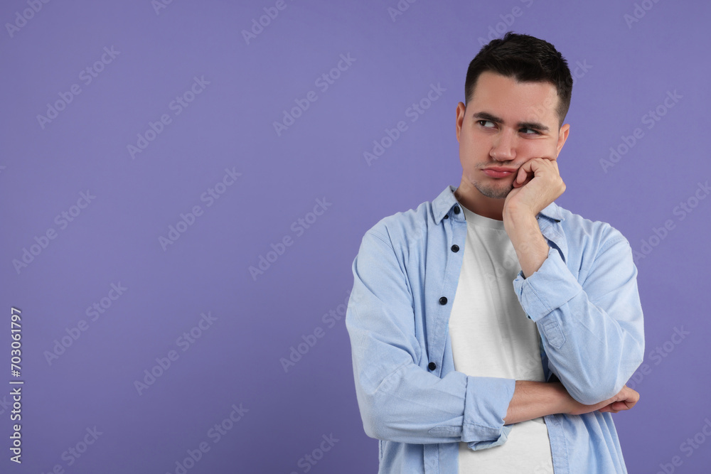 Resentful man on violet background, space for text Resentful man on violet background, space for text