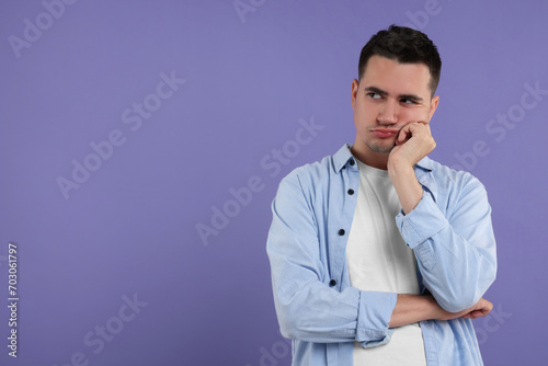 Resentful man on violet background, space for text