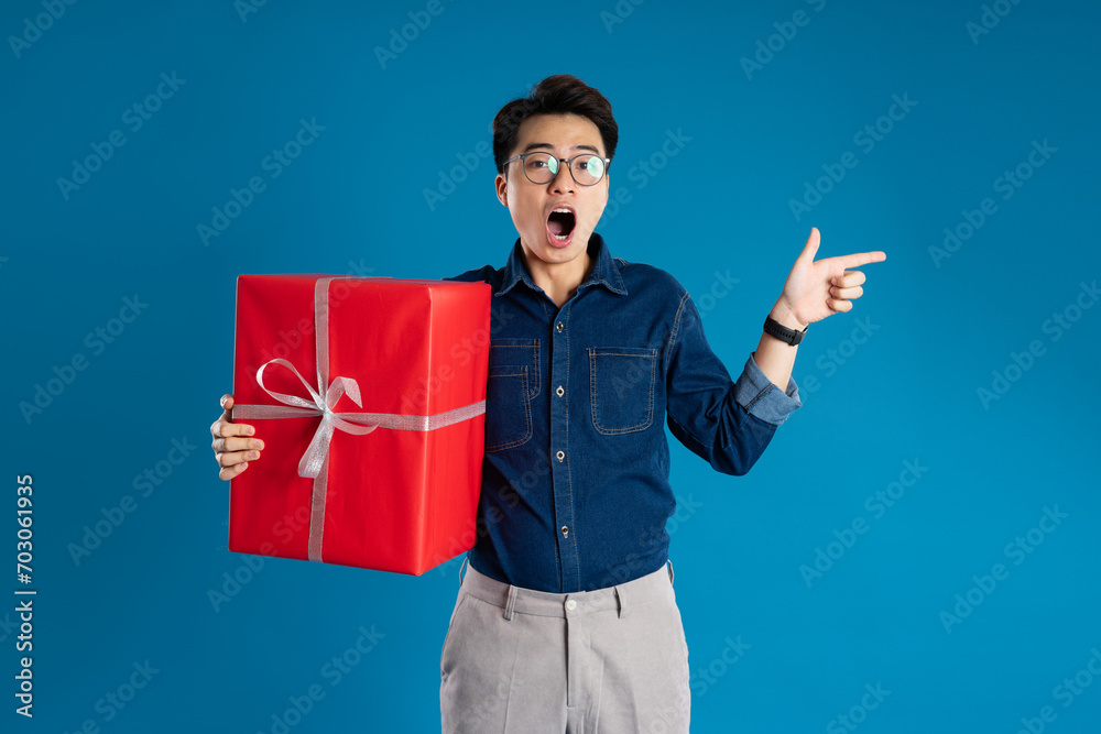 Portrait of young Asian business man posing on blue background Portrait of young Asian business man posing on blue background
