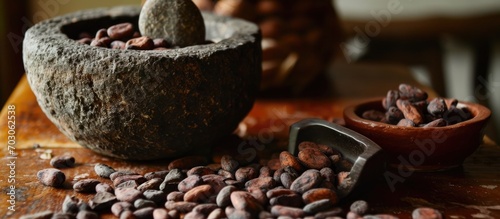 Raw cacao beans and ancient Mayan grinding stone photo