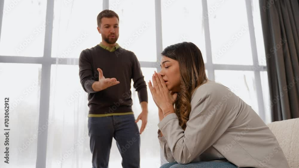 Aggressive man screaming at scared wife at home Aggressive man screaming at scared wife at home