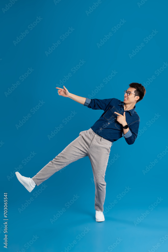 Obraz premium Portrait of young Asian business man posing on blue background