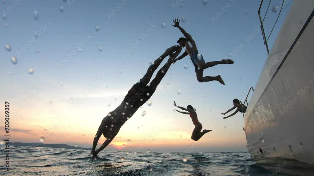 Group of young friends jumping to the beach, having a party in yacht. 