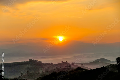 Sunrise on beautiful orange sky on landscape of mountains dawn background © Amphawan
