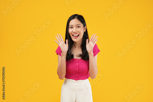 Excited asian woman shout out loud wow with hands on isolated background. Happy shocked face female wow promotion advertising concept. Isolated on yellow background