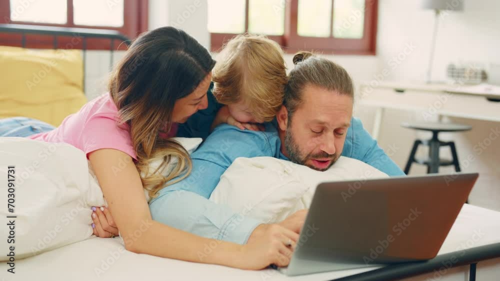 Caucasian attractive family use laptop on bed in the morning at home. Caucasian attractive family use laptop on bed in the morning at home.