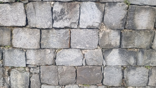 Stone wall pattern. Old castle stone wall background. Part of a stone wall, for background or texture. Seamless background texture with different sized stones. Isolated grey stone wall.