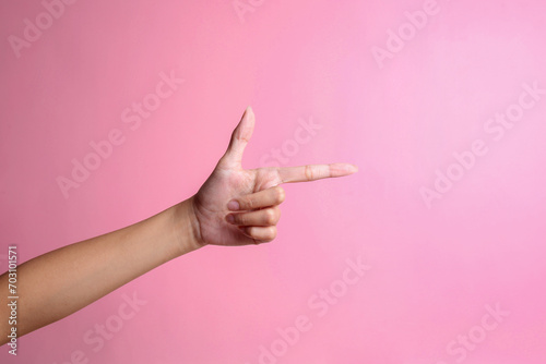 Hand pointing aside isolated on a pink background. It's you gesture photo