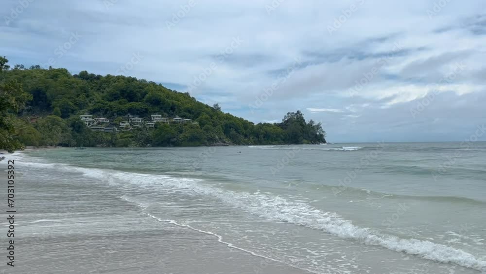 View of waves splashing on seashore. Scenic beach on island against cloudy sky. Concept of beautiful nature. View of waves splashing on seashore. Scenic beach on island against cloudy sky. Concept of beautiful nature.