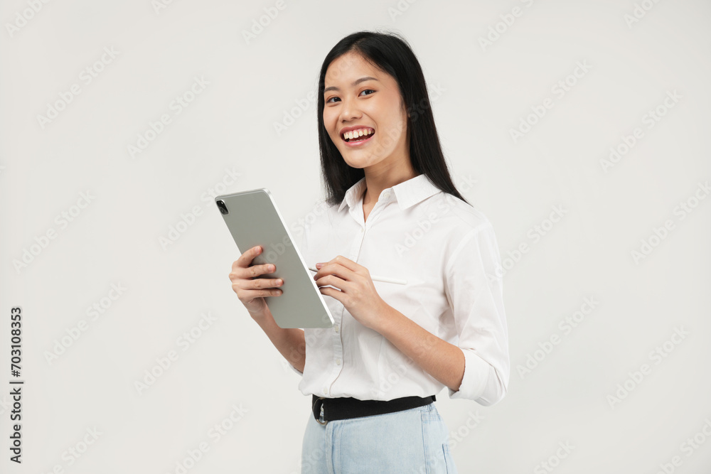 Photo of an Asian woman 20s standing and holding a tablet, dressed a white shirt and isolated on a white background. Photo of an Asian woman 20s standing and holding a tablet, dressed a white shirt and isolated on a white background.