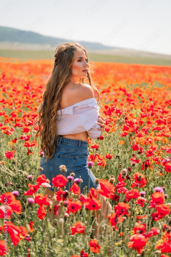 Woman poppies field. Side view of a happy woman with long hair in a poppy field and enjoying the beauty of nature in a warm summer day.