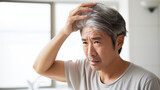 薄毛や白髪に悩む中年男性 Middle aged Asian man worries about hair loss and gray hair