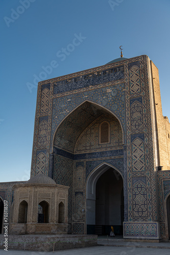 View to Mir i Arab madrassa through old wooden carved door, Bukhara, Uzbekistan