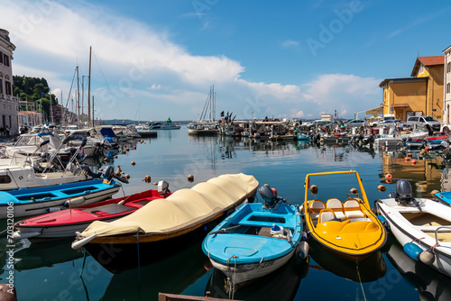 Colorful boats in serene harbor of coastal town Piran, Slovenia, Europe. Tranquil Venetian port in Adriatic Mediterranean sea. Picturesque scene in summer at Slovenian coastline. Sailing trip