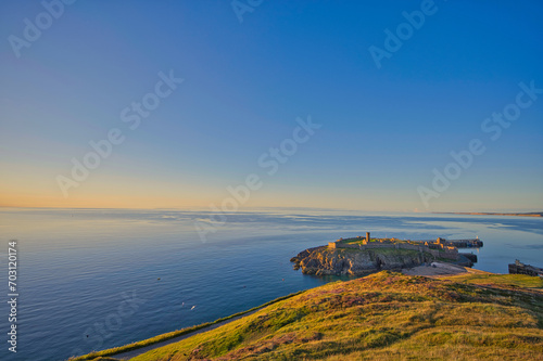 sunset over the sea with a catsle photo