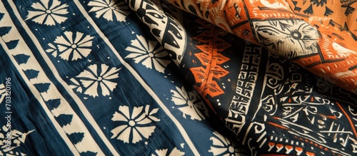 Two Sumatran woven fabric pieces featuring geometric and floral patterns in blue, orange, and white.