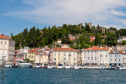 Fishing and sailing boats in serene harbor of coastal town Piran, Slovenia, Europe. Tranquil Venetian port in Adriatic Mediterranean sea. Summer at Slovenian coastline. Scenic view of city wall © Chris