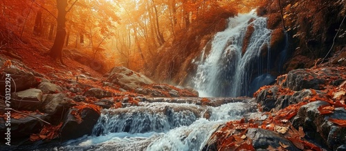 Colorful waterfall in a forest landscape during Autumn season.
