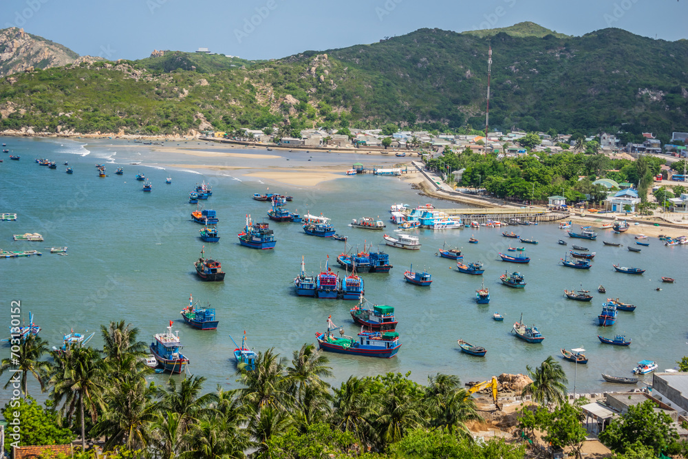 Wooden boats and tourist boats are packed close together in the clear blue water of Vinh Hy Bay, Phan Rang, Ninh Thuan.
