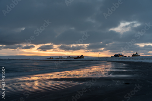 Moody afternoon sky and reflections on wet sand by the sea on a winter afternoon, Skallelv, Northern Norway photo