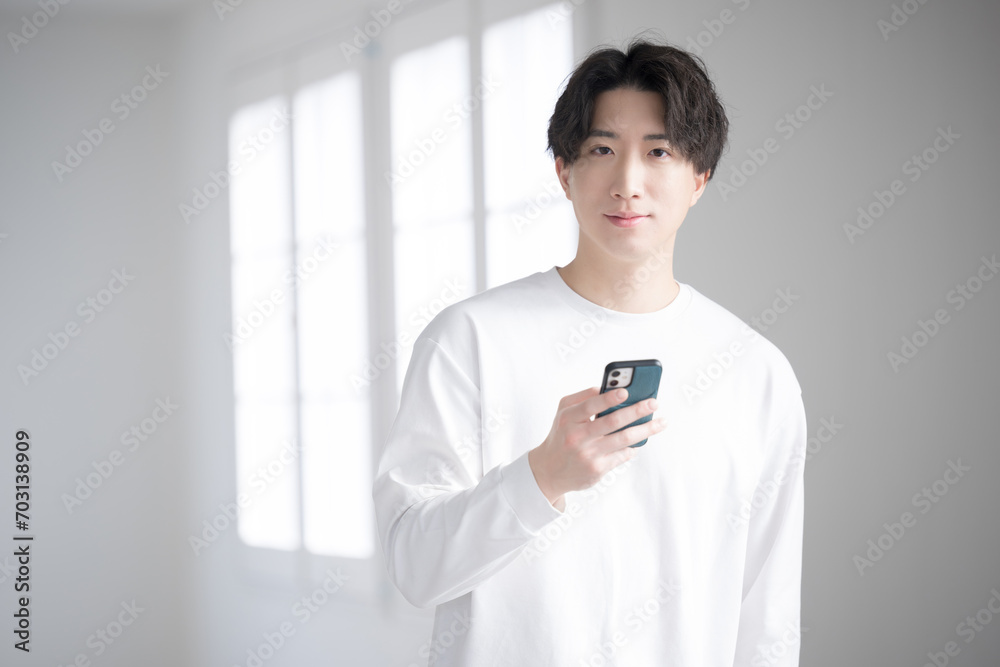 スマホを見るハンサムな男性クローズアップ カメラ目線