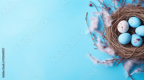 Easter holiday celebration banner greeting card with pastel painted eggs in bird nest on bright blue backround tabel texture. Top view, flat lay with copy space  photo