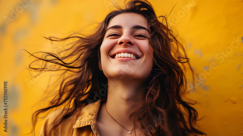 A female smile with her eyes closed, yellow background. Concept for happy well being and wellness