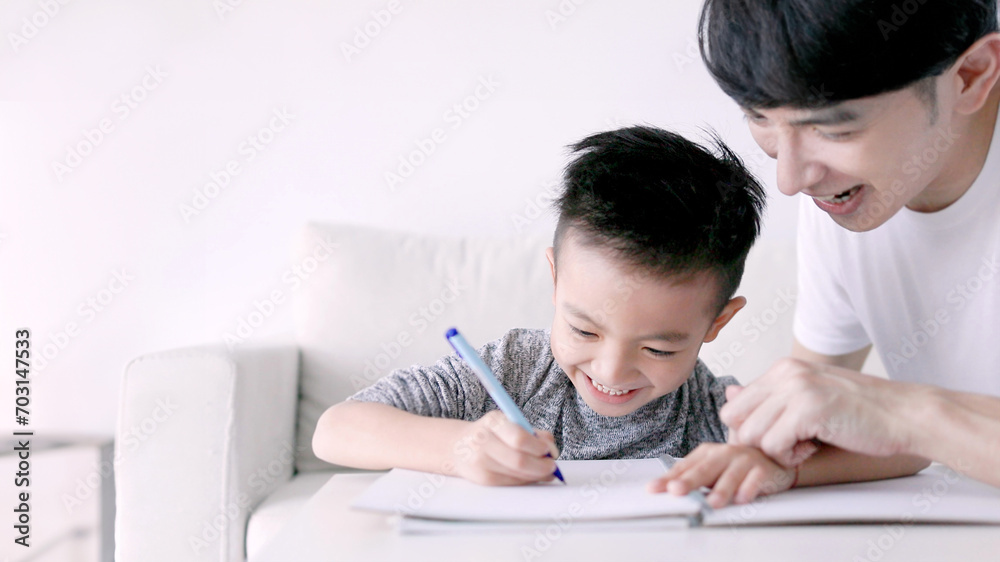Young father checking homework helping child with study at home Young father checking homework helping child with study at home