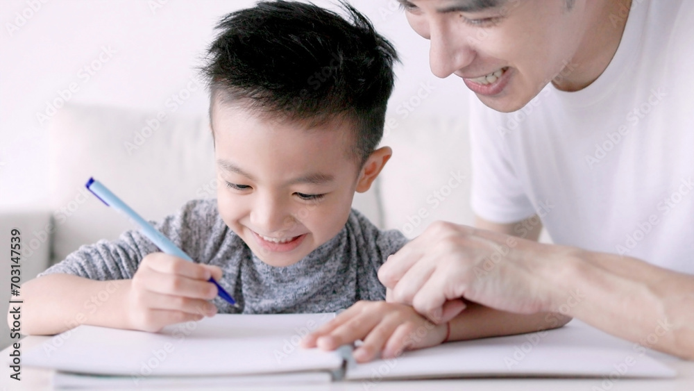 Young father checking homework helping child with study at home Young father checking homework helping child with study at home