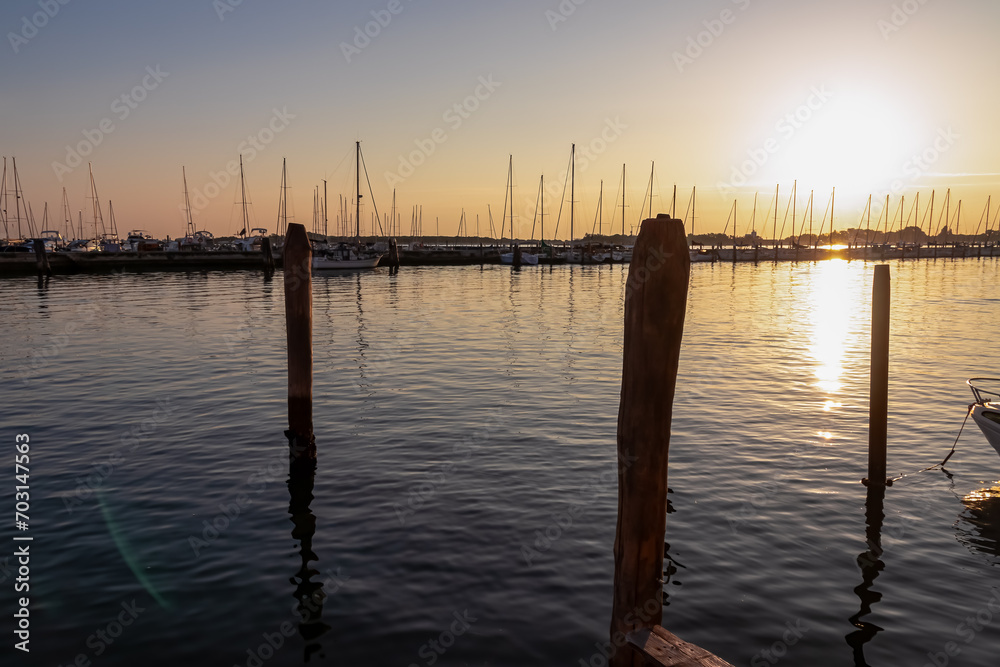 Beautiful sailing boats in picturesque port of charming town of Chioggia at sunrise, nestled in the stunning Venetian Lagoon of the Veneto region in Italy. Tranquil atmosphere in summer Beautiful sailing boats in picturesque port of charming town of Chioggia at sunrise, nestled in the stunning Venetian Lagoon of the Veneto region in Italy. Tranquil atmosphere in summer