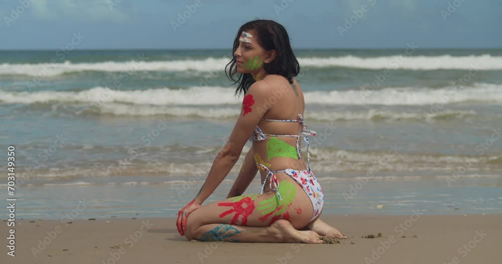Vibrant hues adorned the bikini-clad form of a young girl, creating an artistic display on a Tropical beach in the Caribbean kneel in the sand slow motion Vibrant hues adorned the bikini-clad form of a young girl, creating an artistic display on a Tropical beach in the Caribbean kneel in the sand slow motion