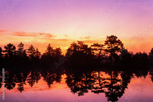 Sunrise over a forest lake with beautiful light