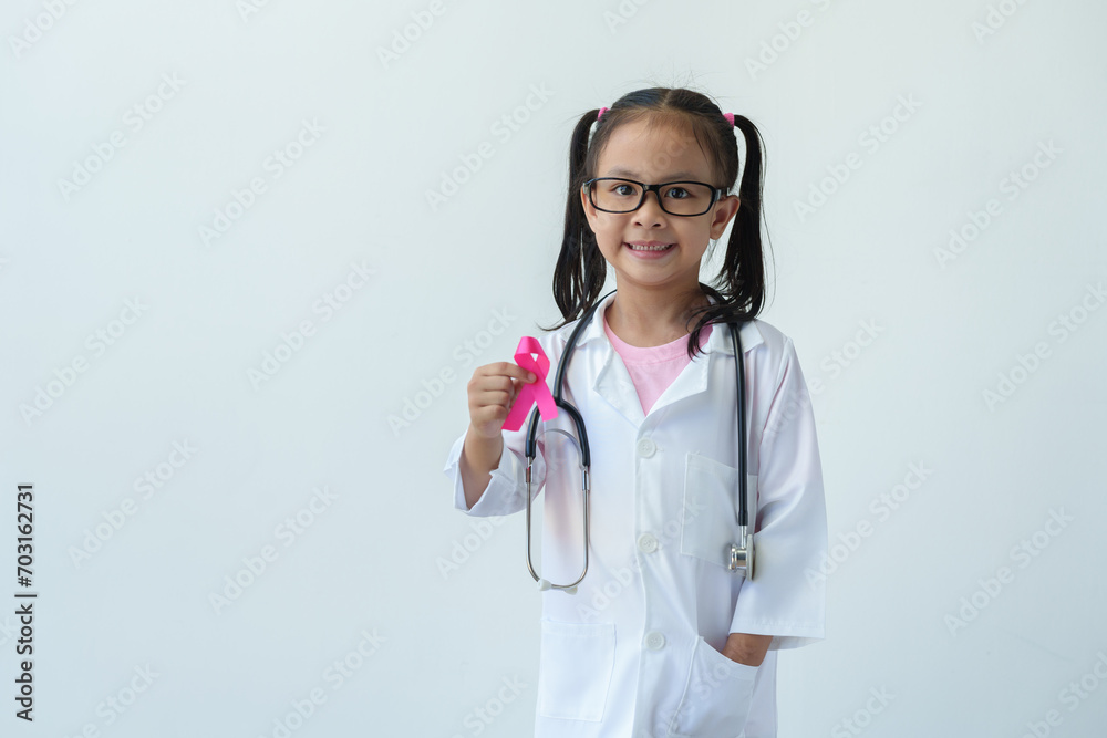 Pink breast cancer campaign A girl in a doctor's uniform with a pink ribbon in a hospital shows the National Fight to Save Lives and Cancer Illness hand sign. Mother and World Cancer Day concept. Pink breast cancer campaign A girl in a doctor's uniform with a pink ribbon in a hospital shows the National Fight to Save Lives and Cancer Illness hand sign. Mother and World Cancer Day concept.