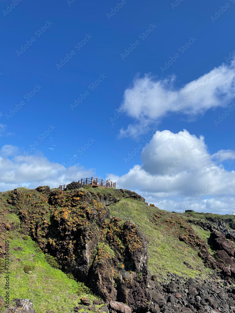 Blue skies, cliffs, grass on rocks