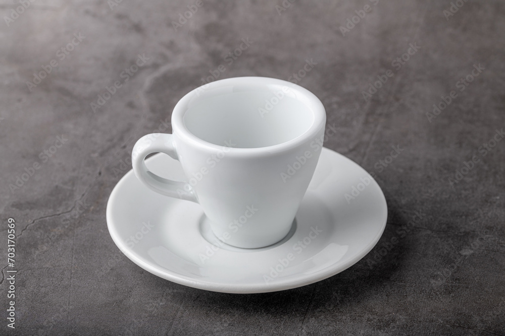 Empty white porcelain cup on gray stone background Empty white porcelain cup on gray stone background