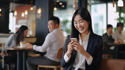 Smiling woman using mobile phone sitting in coffee bar photo